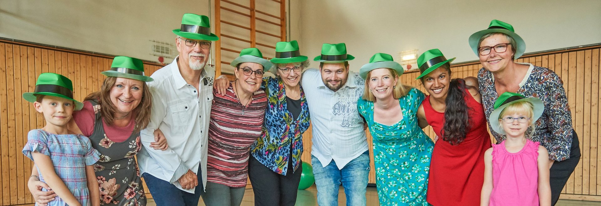 Gruppenbild Menschen mit grünen Hüten